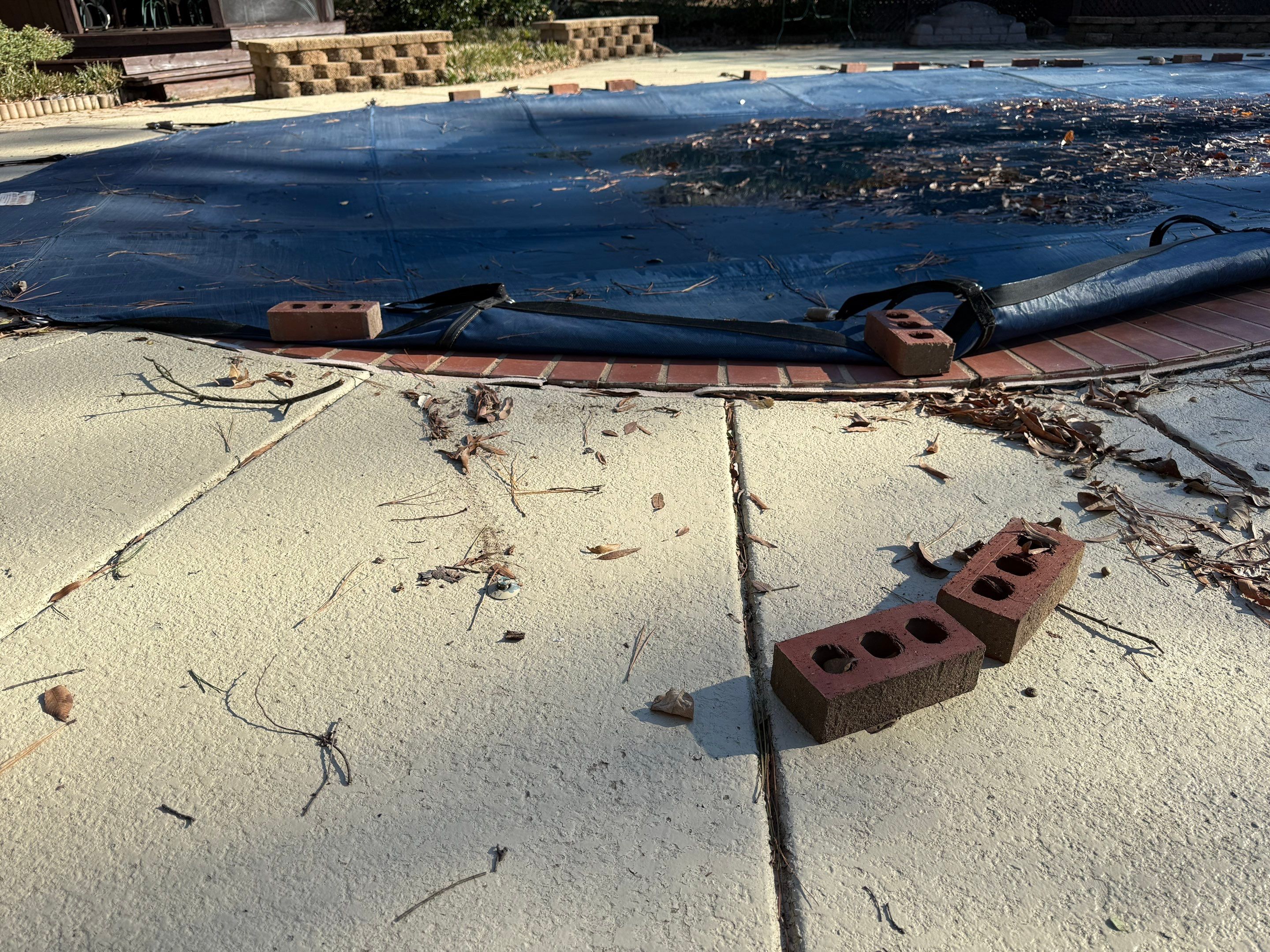 Rainwater pooling at the edge of a tilted pool deck